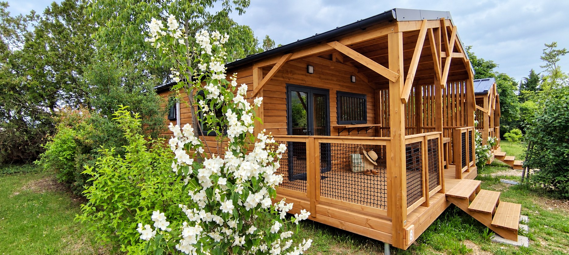 Le chalet Sésame et sa terrasse couverte dans la végétation des Chamberts