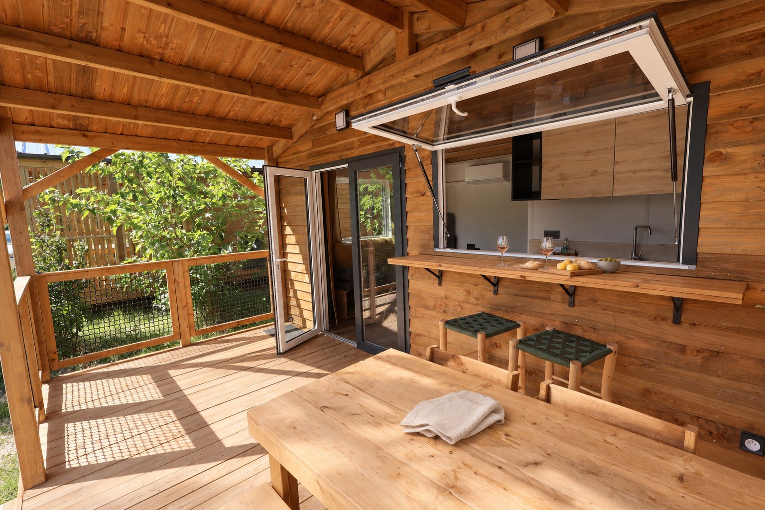 Fenêtre-bar ouverte entre la cuisine et la terrasse du chalet Sésame